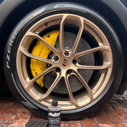 Clear Gel Tyre Shine, with applicator sponge, in front of Porsche Rim and Tyre